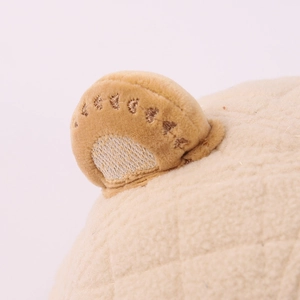 Dettaglio del cappello in peluche per neonati con trama trapuntata e orecchio