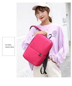 Detail view of the pink canvas backpack featuring a black BOYU brand logo tag
