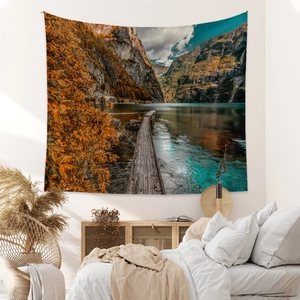 Bohemian wall tapestry showing mountain lake landscape above bed in modern bedroom decoration