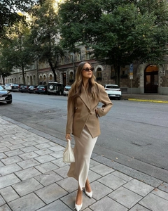 Fashionable brown double-breasted blazer paired with a long cream silk dress and accessories