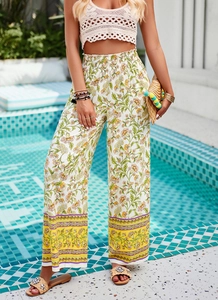 Détail du pantalon large à fleurs avec motif vert-jaune et bordure colorée