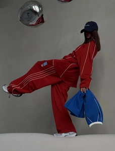 Close-up of red sporty hoodie and wide-leg pants set with side stripe detailing