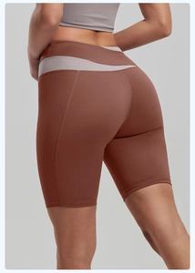 Detail of high-waisted color-block fitness shorts with brick red and grey panels