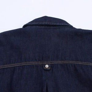Détail d'une chemise en jean bleu foncé montrant l'encolure arrière et les coutures