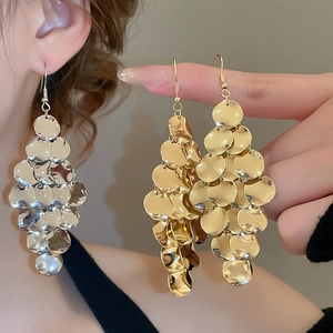 Macro detail of multi-layered metallic disc sequin drop earrings in gold and silver finish