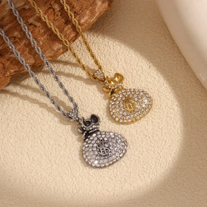 Detailed view of gold and silver money bag pendants with pavé crystals on twist chains