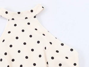 Détail de l'encolure licou à pois et texture plissée du tissu sur robe crème