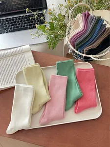 Macro shot of assorted colorful ribbed cotton socks in a decorative tray setup