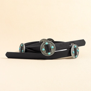Detail of vintage black leather belt featuring silver concho studs and turquoise stones