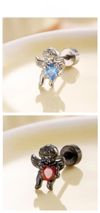 Macro shot of silver and black angel stud earrings with blue and red heart-shaped zircon