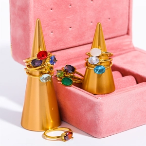 Gold stainless steel birthstone rings with colorful zircon crystals in a pink jewelry box