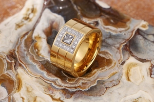 Detailed close-up of wide gold-plated stainless steel ring with square zircon stones