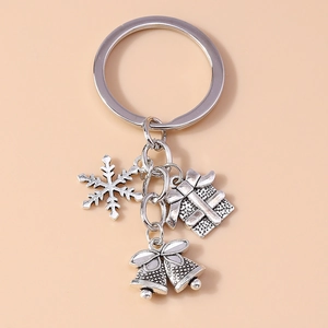 Close-up of silver alloy keychain featuring snowflake, gift box, and bell charms