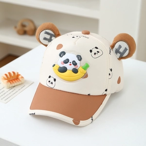 Detail of kids baseball cap with cute 3D panda ears and banana emblem on white desk