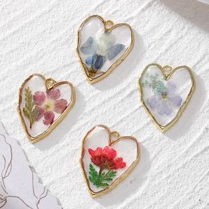 Handmade gold heart pendants with real dried flowers and glitter in four vibrant colors