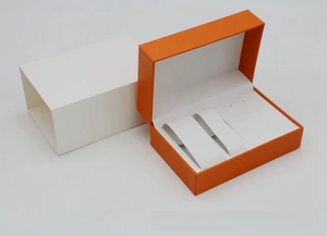 Detail view of orange PU leather watch set box with white outer sleeve and inner slots