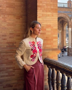 Close-up of ethnic floral embroidery on a cream short jacket with stand-up collar