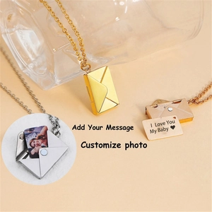 Macro detail of envelope locket necklace in gold, silver, and rose gold finishes