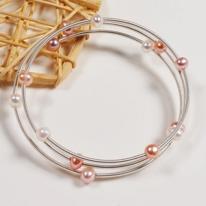 Detailed macro shot of triple-layer handmade freshwater pearl wrap bracelet in silver wire
