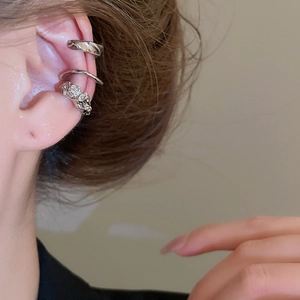 Vue macro de trois boucles d'oreilles argentées irrégulières aux textures polies et lave