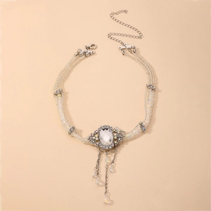Détail du ras-du-cou en perles baroques avec pendentif cristal et pompons