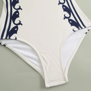 Detailed close-up of high-elasticity white swimwear fabric with blue fish patterns