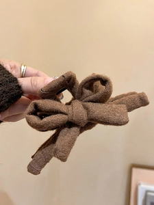 Gros plan sur la pince à cheveux noeud en tissu marron avec texture hivernale