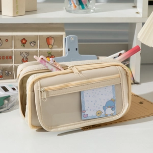 Close-up of a cream canvas pencil case featuring a three-layer zipper and clear card slot