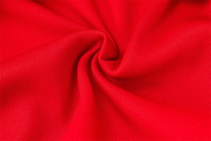 Detailed view of red knitted fabric texture with elegant pleated effect on a party dress