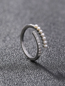 Close-up of adjustable silver ring featuring micro-set pearls and shimmering cubic zirconia