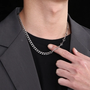 Polished silver Cuban link necklace with unique bar connection worn by a fashion model