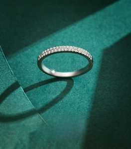 Macro detail of S925 sterling silver double row pavé ring on dark green background