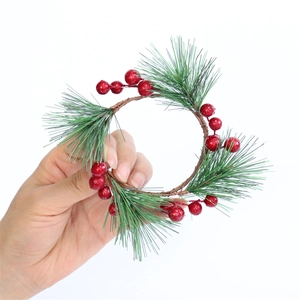 Weihnachtskranz mit künstlichen Tannennadeln und roten Beeren auf weißem Hintergrund in der Hand