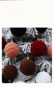 Close-up of textured flocked Christmas balls with ripple patterns hanging on a snowy tree