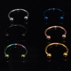 Close-up of 16G stainless steel horseshoe rings in six metallic finishes on black background
