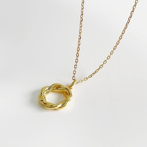 Elegant 925 silver necklace with golden twisted wreath pendant on white background
