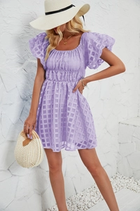 Détails de la texture à carreaux lilas et des manches bouffantes sur la robe courte