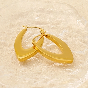 Detailed close-up of gold V-shaped stainless steel earrings on a glass plate