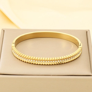 Detailed macro of 18K gold plated bangle with crystal diamonds on jewelry box