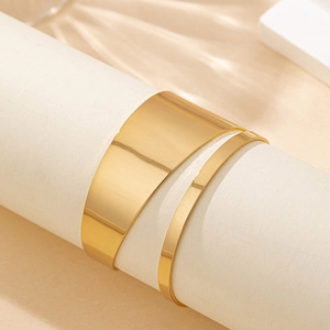 Irregular hollow open cuff bracelet in polished gold finish with a minimalist tapered design