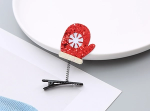 Détail d'une pince à cheveux gant de Noël en paillettes rouges avec flocon de neige
