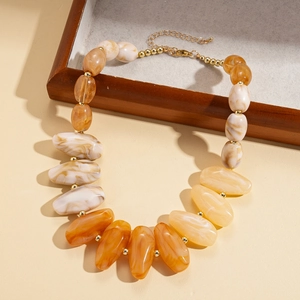 Detailed close-up of amber acrylic geometric beads and golden metallic spacer beads