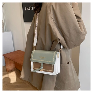 Detail of green and brown contrast square bag with stylish printed wide shoulder strap
