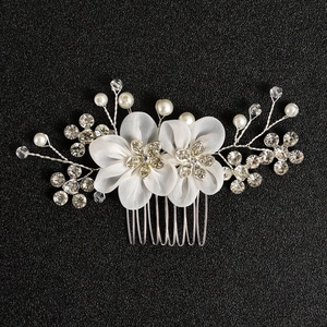Detailed view of handmade organza flowers with rhinestones and pearls on bridal hair comb