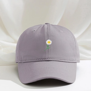 Dettaglio del ricamo a margherita su un cappellino da baseball in cotone viola polvere