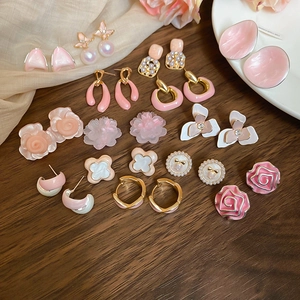 Flat lay of pink floral and pearl stud earrings set with gold-tone metal alloy details