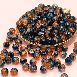 Macro detail of 10mm blue and amber cracked glass beads for DIY jewelry making