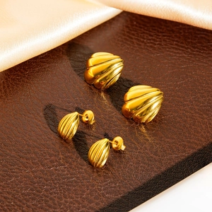 Elegante goldene Titanstahl-Ohrringe mit Streifenmuster auf luxuriösem Seidenhintergrund