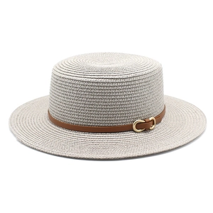 Détail d'un chapeau de paille à haut plat avec bande en simili cuir et boucle dorée
