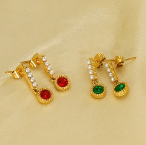 Detail of vintage gold drop earrings with oval pearls, red and green gemstones on satin